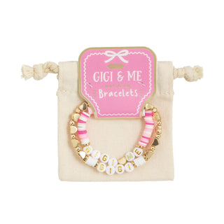 Set of bracelets with 'GIGI & ME' branding on a beige pillow with a pink card.