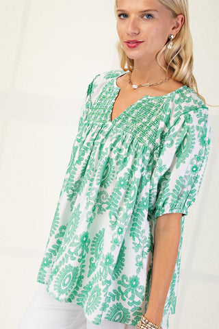 Woman wearing a green patterned dress against a white background