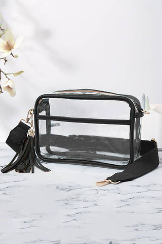 Clear pouch with black strap and tassel on a marble surface