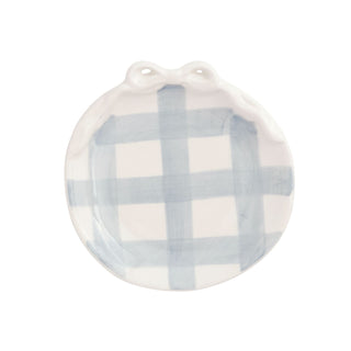 Round ceramic trivet with blue and white checkered pattern on a white background
