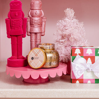 Decorative items including pink nutcrackers, a small tree, and wrapped gifts on a pink stand.