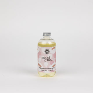 Bottle of 'sweet grace' flower diffuser refill on a white background