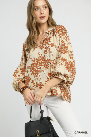 Woman wearing a floral blouse with a black handbag on a white background