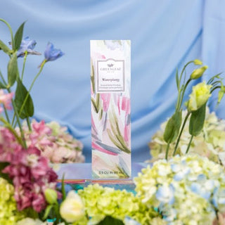 Floral arrangement with a 'Chamomile' product packaging against a blue background