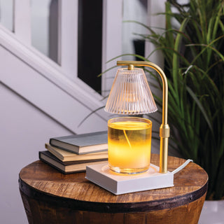 Decorative lamp on a wooden table with books and a plant in the background