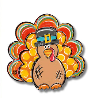 Colorful turkey-shaped decoration with a top hat next to a ruler on a white background