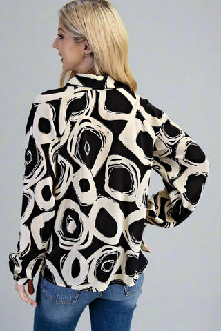 Woman wearing a black and white patterned shirt against a gray background