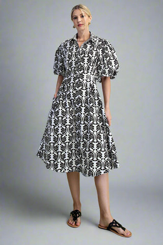 Woman wearing a black and white patterned dress on a gray background