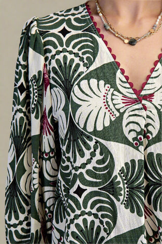 Close-up of a patterned dress with green, white, and red design.