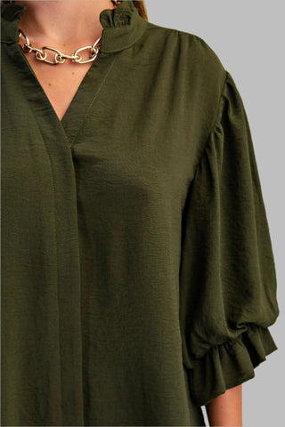 Green blouse with ruffled sleeves on a plain background