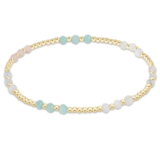 Beaded bracelet with gold, turquoise, and white beads on a white background